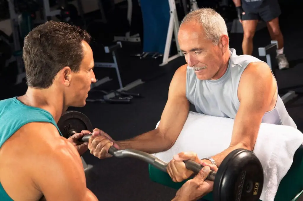 fitness & longevity instructor providing a weight training workout to a senior to enhance muscle after 50
